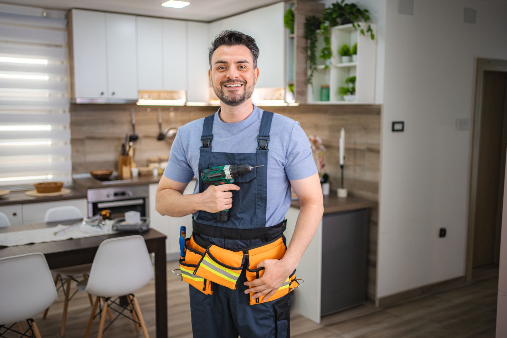 handyman-smiling-and-holding-cordless-drill-in-kit-2026-01-09-10-12-18-utc